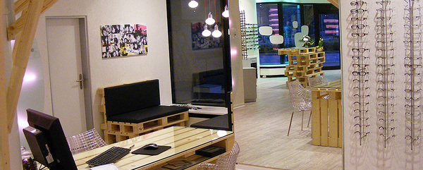 Modernes Optikergeschäft mit Brillenregalen, Beratungstisch und stilvollem Interieur.